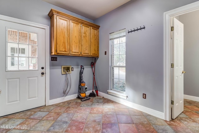 laundry area featuring cabinet space, hookup for a washing machine, baseboards, and light tile patterned floors