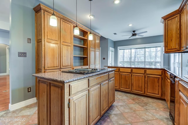 kitchen featuring brown cabinets, a kitchen island, ceiling fan, a peninsula, and black appliances