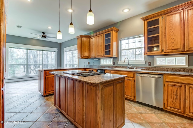 kitchen with brown cabinets, a sink, stainless steel dishwasher, and black electric cooktop