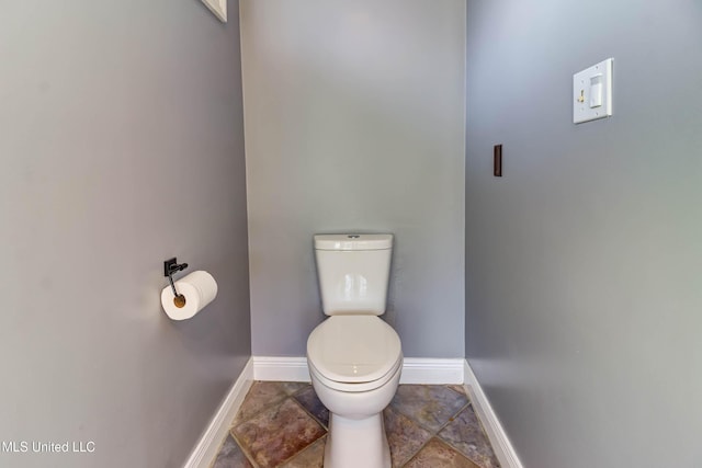 bathroom featuring toilet and baseboards