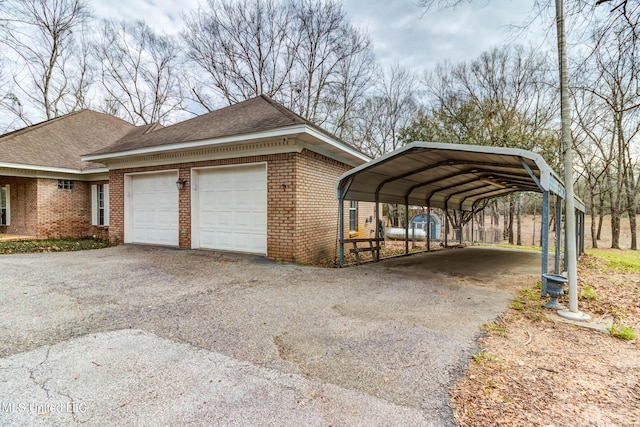 view of side of property featuring a garage, driveway, and brick siding