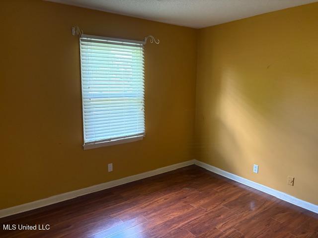 3 Pemberton Cir, Greenwood, MS 38930 - spare room with wood finished floors, baseboards, and healthy amount of natural light