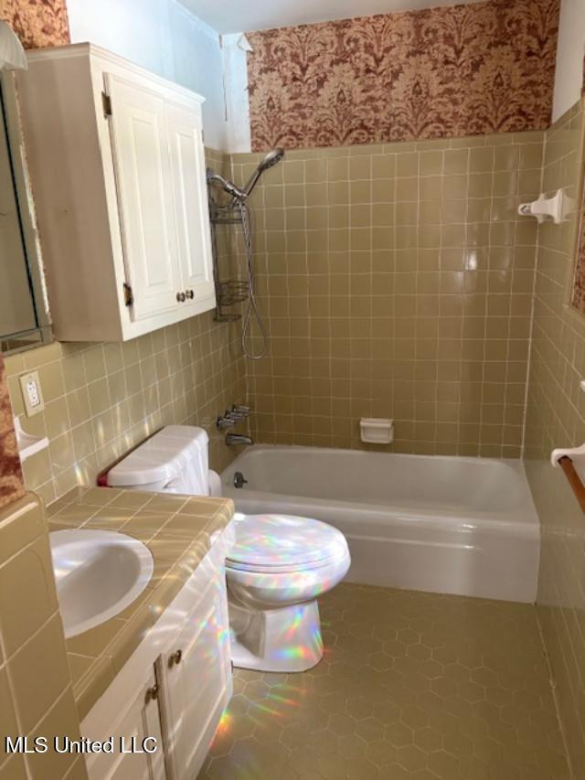 3 Pemberton Cir, Greenwood, MS 38930 - full bath with wallpapered walls, shower / bath combination, toilet, vanity, and tile walls