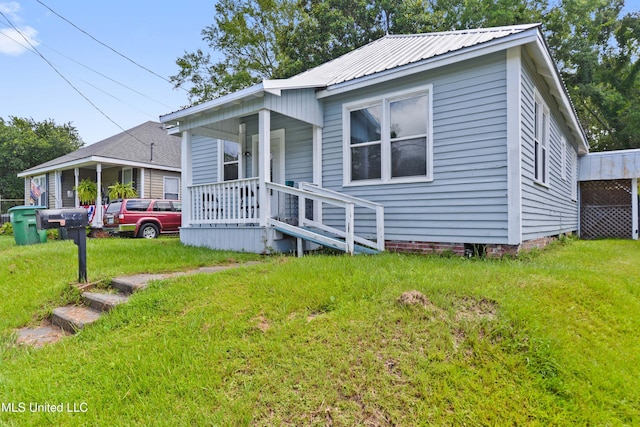 4006 Pine St, Pascagoula, MS 39567 - bungalow-style house with a front lawn, a metal roof, and a porch