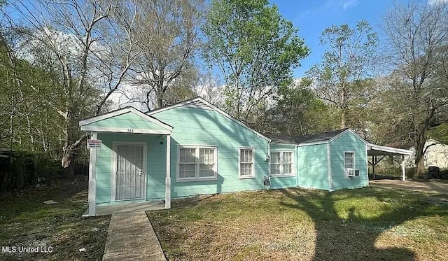 view of front of house with a front lawn and a carport