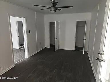 unfurnished bedroom with dark hardwood / wood-style flooring and ceiling fan