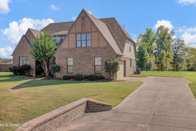 view of front of home with a front yard, central AC, and a garage