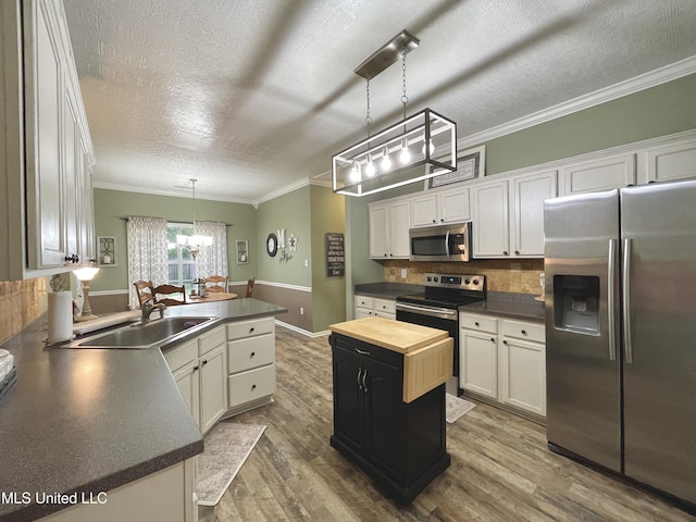 5269 Blocker St, Olive Branch, MS 38654 - kitchen with appliances with stainless steel finishes, a chandelier, a textured ceiling, wood finished floors, and butcher block countertops