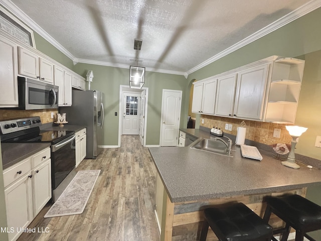 5269 Blocker St, Olive Branch, MS 38654 - kitchen featuring stainless steel appliances, dark countertops, open shelves, a peninsula, and ornamental molding