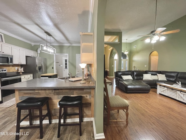 5269 Blocker St, Olive Branch, MS 38654 - kitchen with stainless steel appliances, arched walkways, dark countertops, dark wood-type flooring, and a textured ceiling