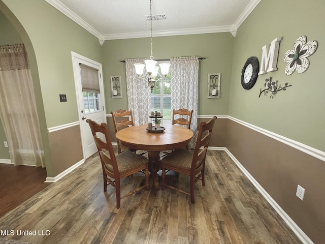 5269 Blocker St, Olive Branch, MS 38654 - dining space featuring wood finished floors, crown molding, arched walkways, and a chandelier