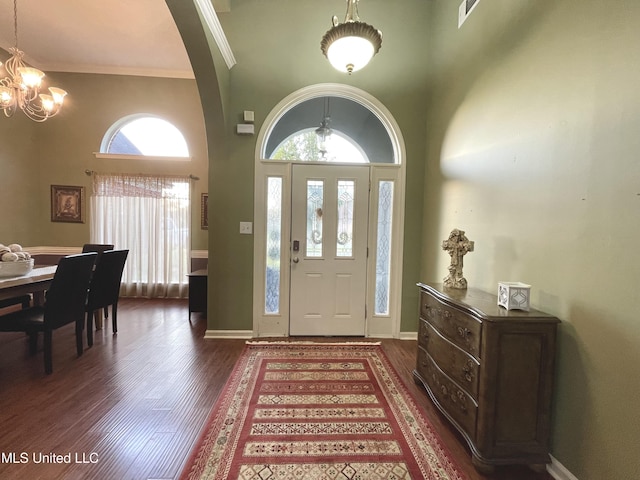 5269 Blocker St, Olive Branch, MS 38654 - foyer with a chandelier, arched walkways, a towering ceiling, dark wood-style flooring, and crown molding