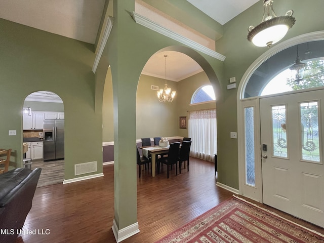 5269 Blocker St, Olive Branch, MS 38654 - foyer featuring a high ceiling, arched walkways, dark wood finished floors, and a chandelier