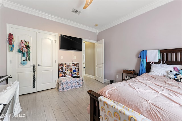 bedroom with light hardwood / wood-style flooring, a closet, ornamental molding, and ceiling fan