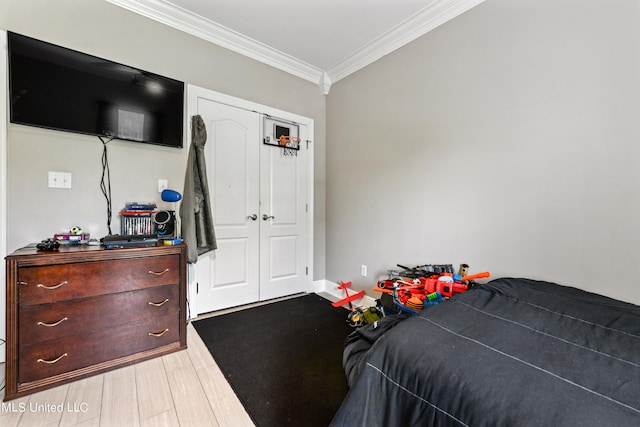 bedroom with a closet, crown molding, and light wood-type flooring