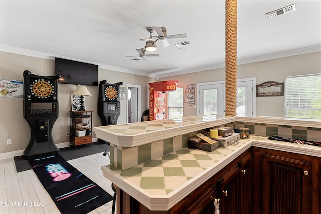 kitchen featuring crown molding, plenty of natural light, and light wood-type flooring