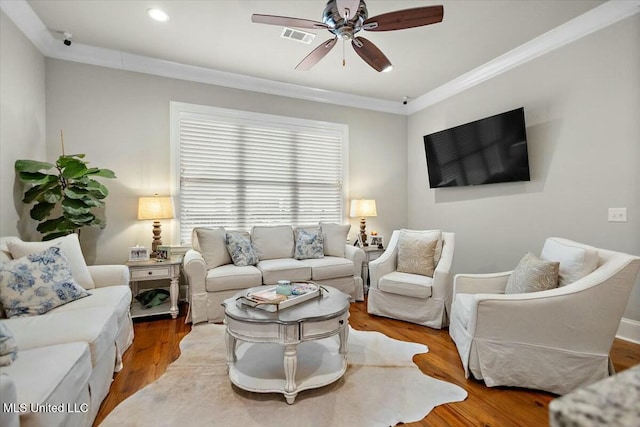 living room with hardwood / wood-style flooring, ceiling fan, and crown molding