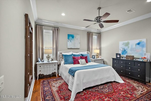 bedroom featuring dark wood-type flooring, ceiling fan, and ornamental molding