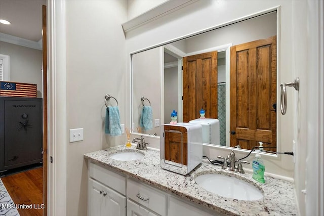 bathroom with wood-type flooring, vanity, and ornamental molding