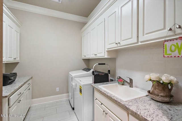 washroom featuring cabinets, crown molding, sink, independent washer and dryer, and light tile patterned floors