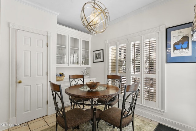 dining space with light tile patterned floors, baseboards, ornamental molding, and a notable chandelier