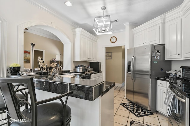 kitchen featuring a peninsula, dark countertops, white cabinetry, and stainless steel appliances