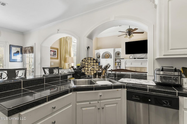 kitchen with ornamental molding, white cabinets, a sink, ceiling fan, and dishwasher