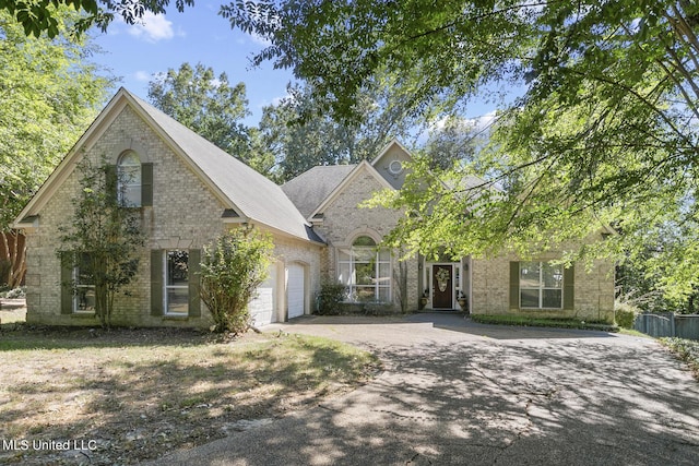 view of front of house with brick siding, driveway, and an attached garage