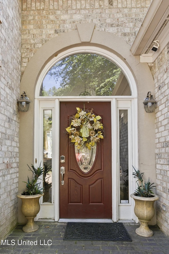 view of exterior entry featuring brick siding