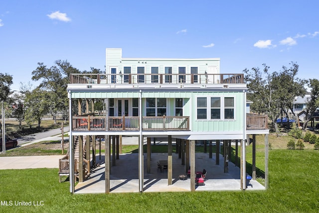 rear view of house featuring a carport, a yard, a patio area, and board and batten siding