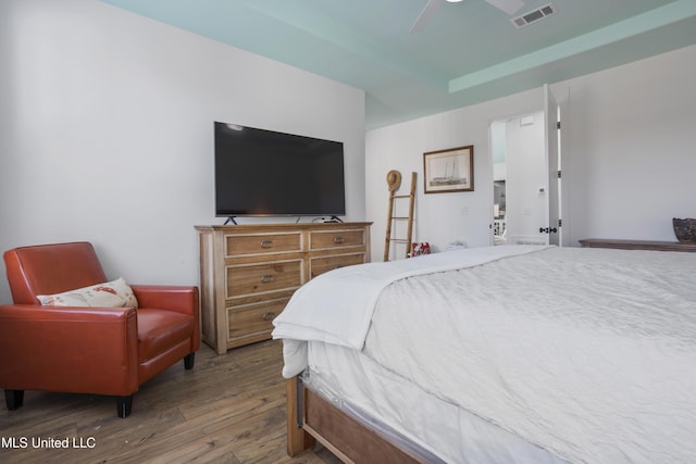 bedroom with visible vents, a ceiling fan, and wood finished floors