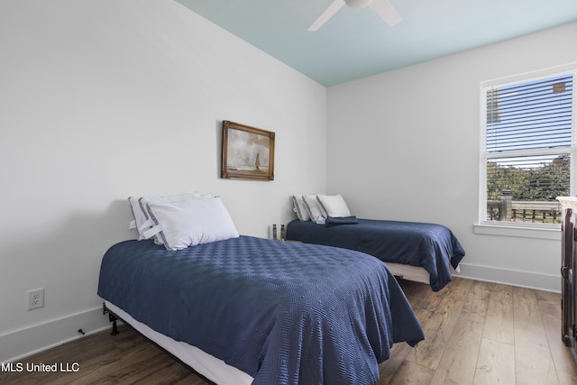 bedroom with ceiling fan, baseboards, and wood finished floors