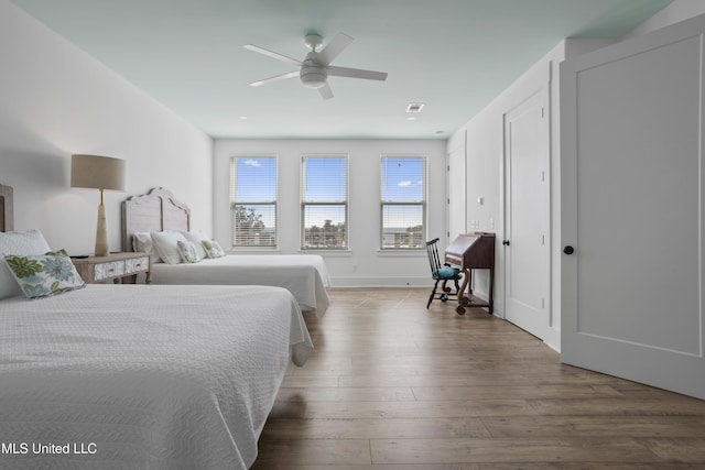 bedroom with ceiling fan, visible vents, and wood finished floors