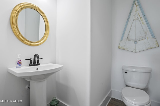 bathroom featuring baseboards and toilet