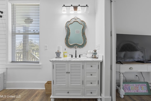 bathroom with vanity, wood finished floors, and baseboards