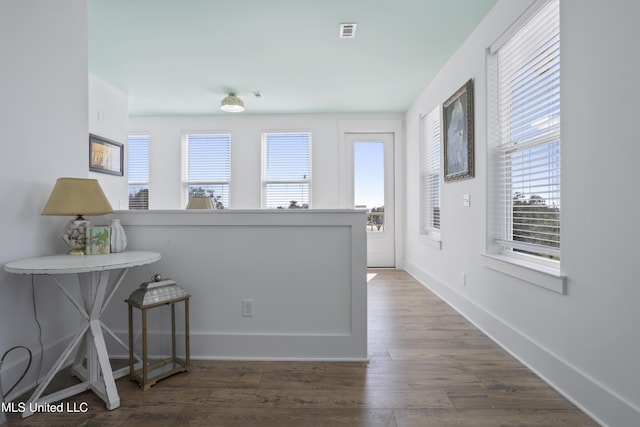 interior space with wood finished floors, visible vents, and baseboards