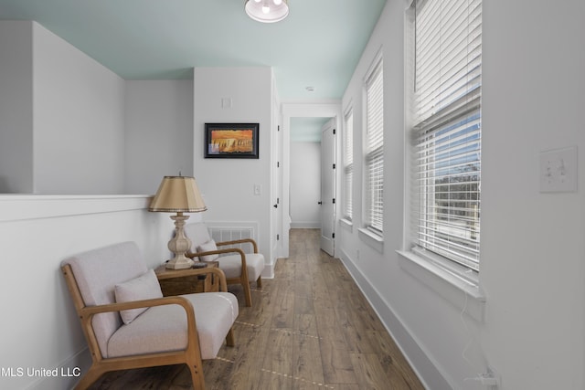 corridor with baseboards and wood-type flooring