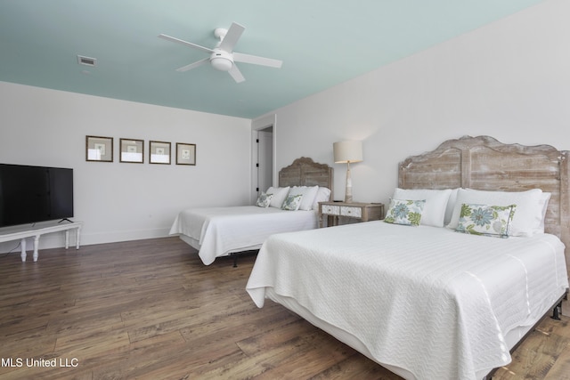 bedroom featuring a ceiling fan, visible vents, wood finished floors, and baseboards