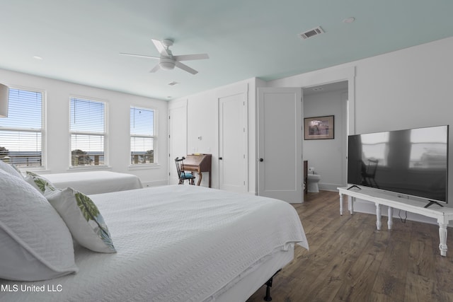 bedroom featuring a ceiling fan, wood finished floors, visible vents, and baseboards