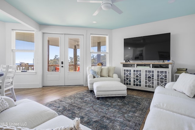 living room featuring a ceiling fan, wood finished floors, baseboards, and french doors