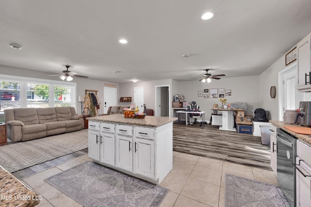 kitchen featuring a kitchen island, white cabinetry, dishwasher, and light tile patterned floors