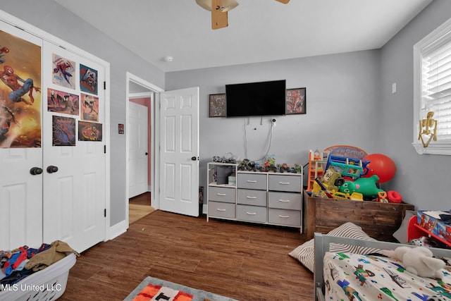 bedroom with ceiling fan, a closet, and dark hardwood / wood-style flooring