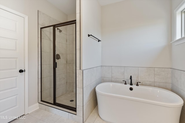 1728 Ryker Rd, Southaven, MS 38672 - bathroom featuring a soaking tub, a shower stall, tile patterned floors, and tile walls