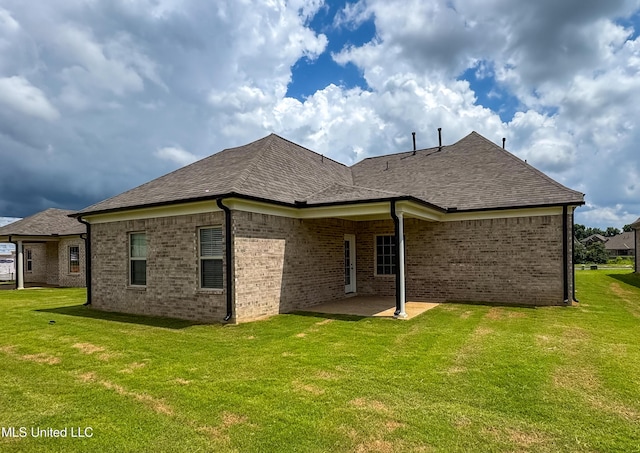 1728 Ryker Rd, Southaven, MS 38672 - back of house featuring a patio, a yard, brick siding, and a shingled roof