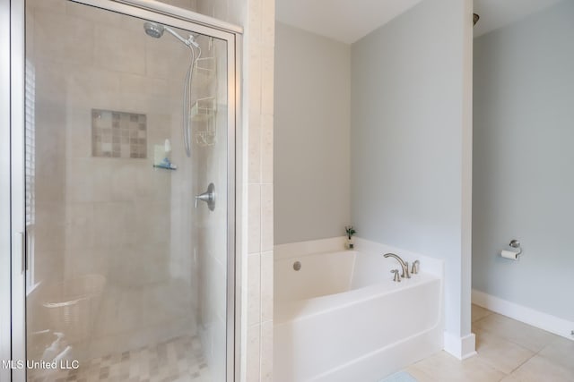 bathroom with a stall shower, tile patterned flooring, and a bath