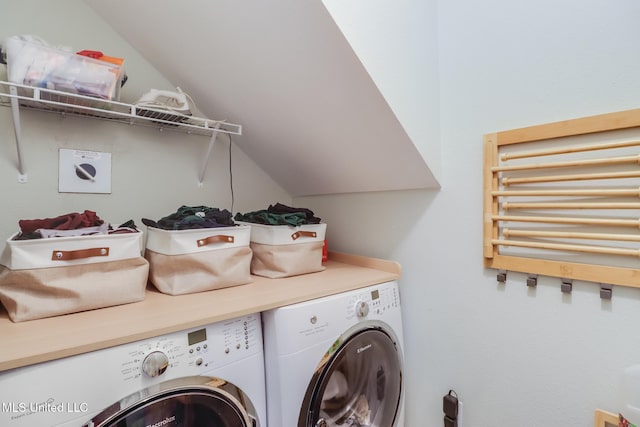 clothes washing area featuring radiator, washing machine and clothes dryer, and laundry area