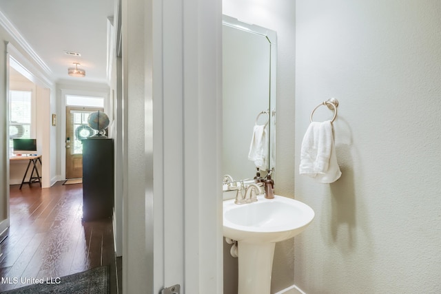 bathroom with ornamental molding and hardwood / wood-style floors