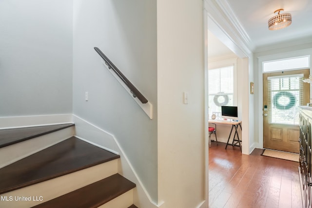 stairway with hardwood / wood-style floors, ornamental molding, and baseboards