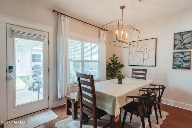dining room with dark wood-style floors, baseboards, and an inviting chandelier
