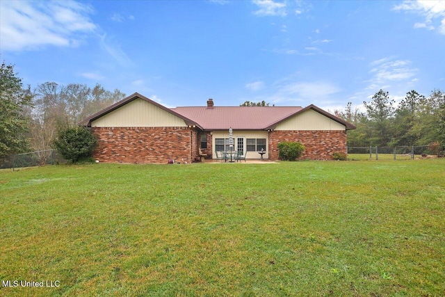 rear view of property with a yard and a patio